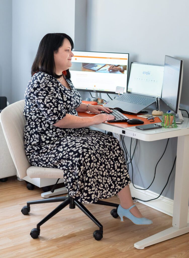 Mel Whiteside, a white woman with dark hair, sat at her desk working on her computer.